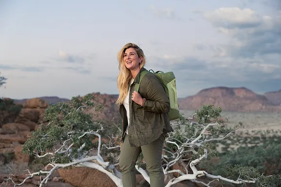 Abenteurerin vor einem Savannen-Panorama